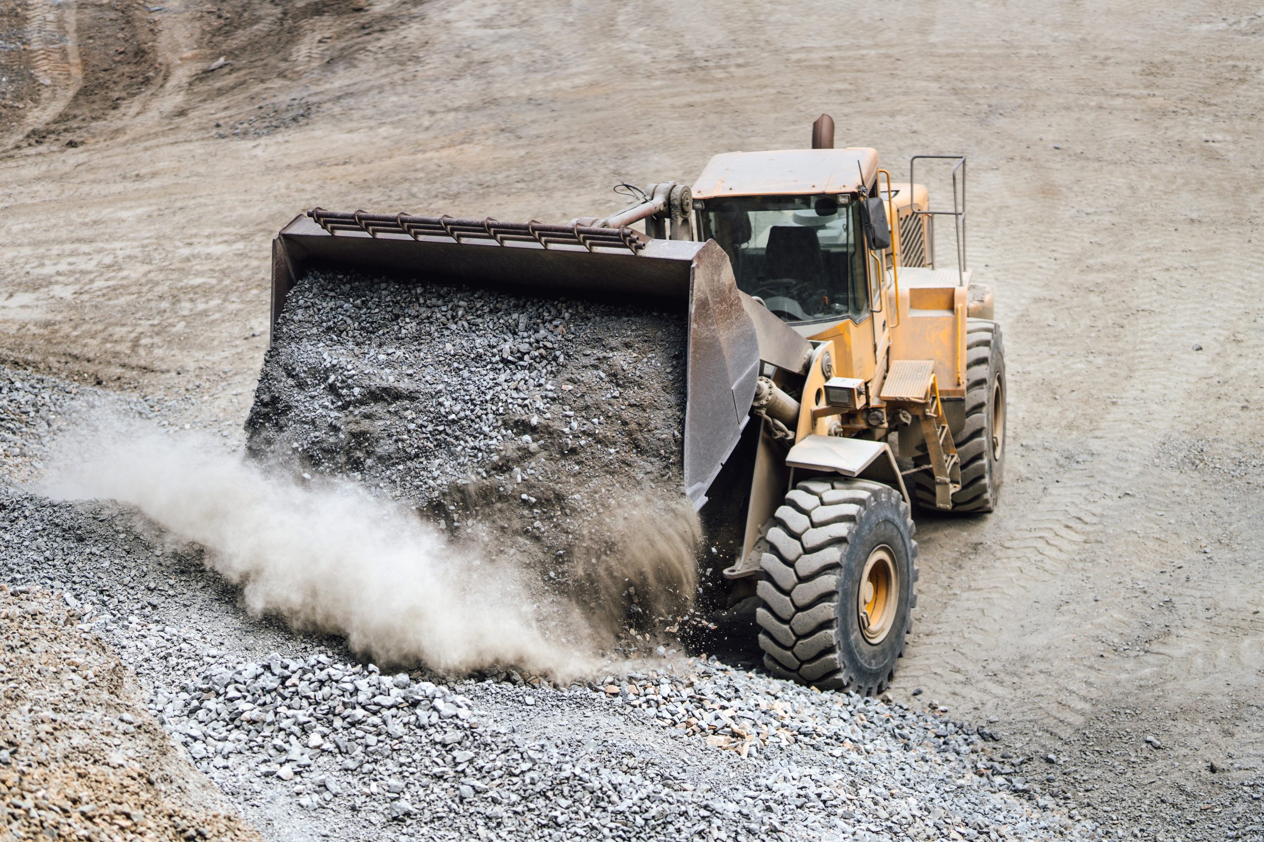 Industrial heavy bulldozer moving gravel on highway construction site. Multiple industrial machinery on construction site