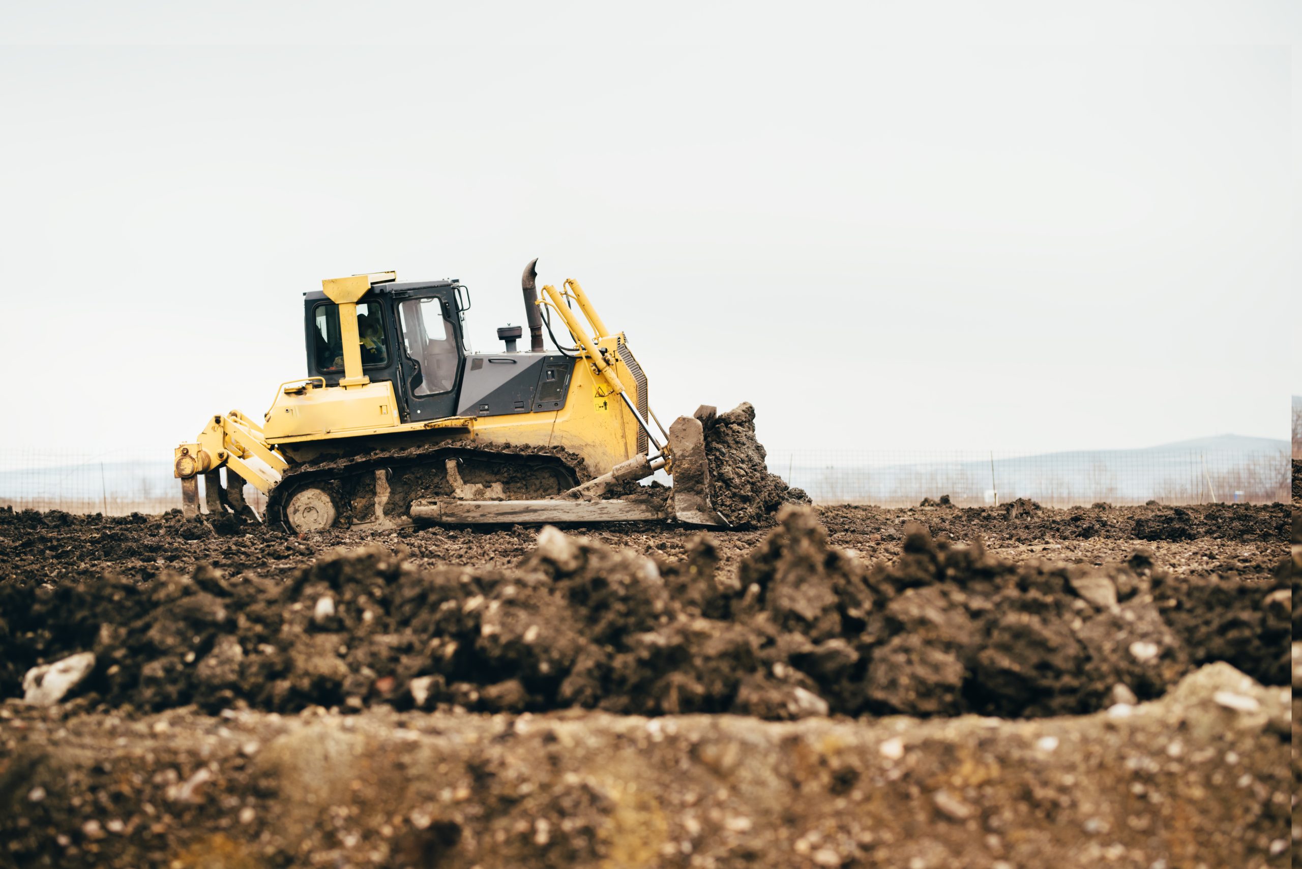 mini industrial bulldozer moving dirt and earth with scoop. Industrial details of landscaping